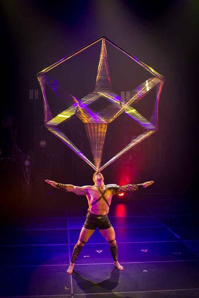 Le cube en équilibre sur la tête, bras ouverts